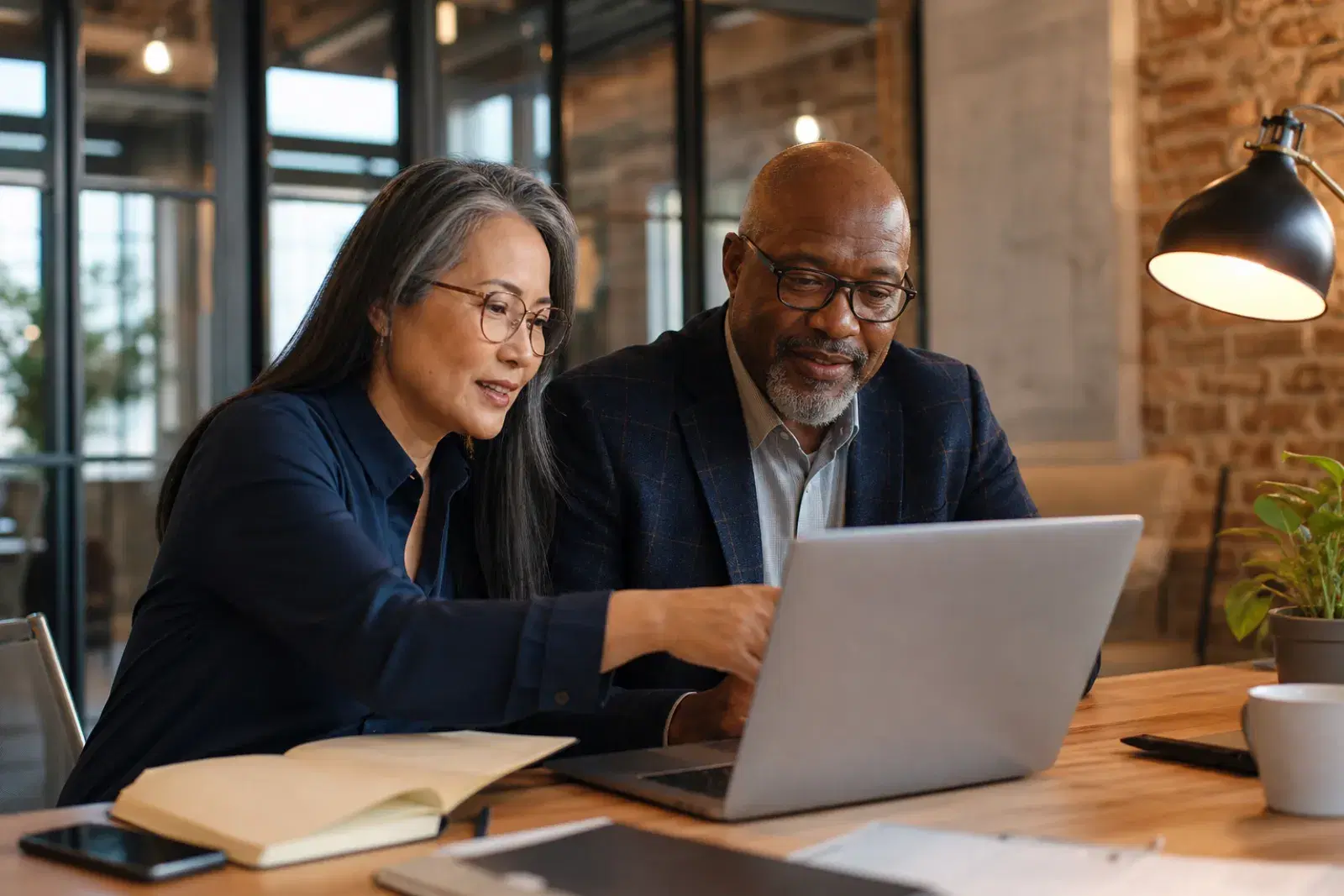 Two people reviewing playback of a presentation together on a laptop.