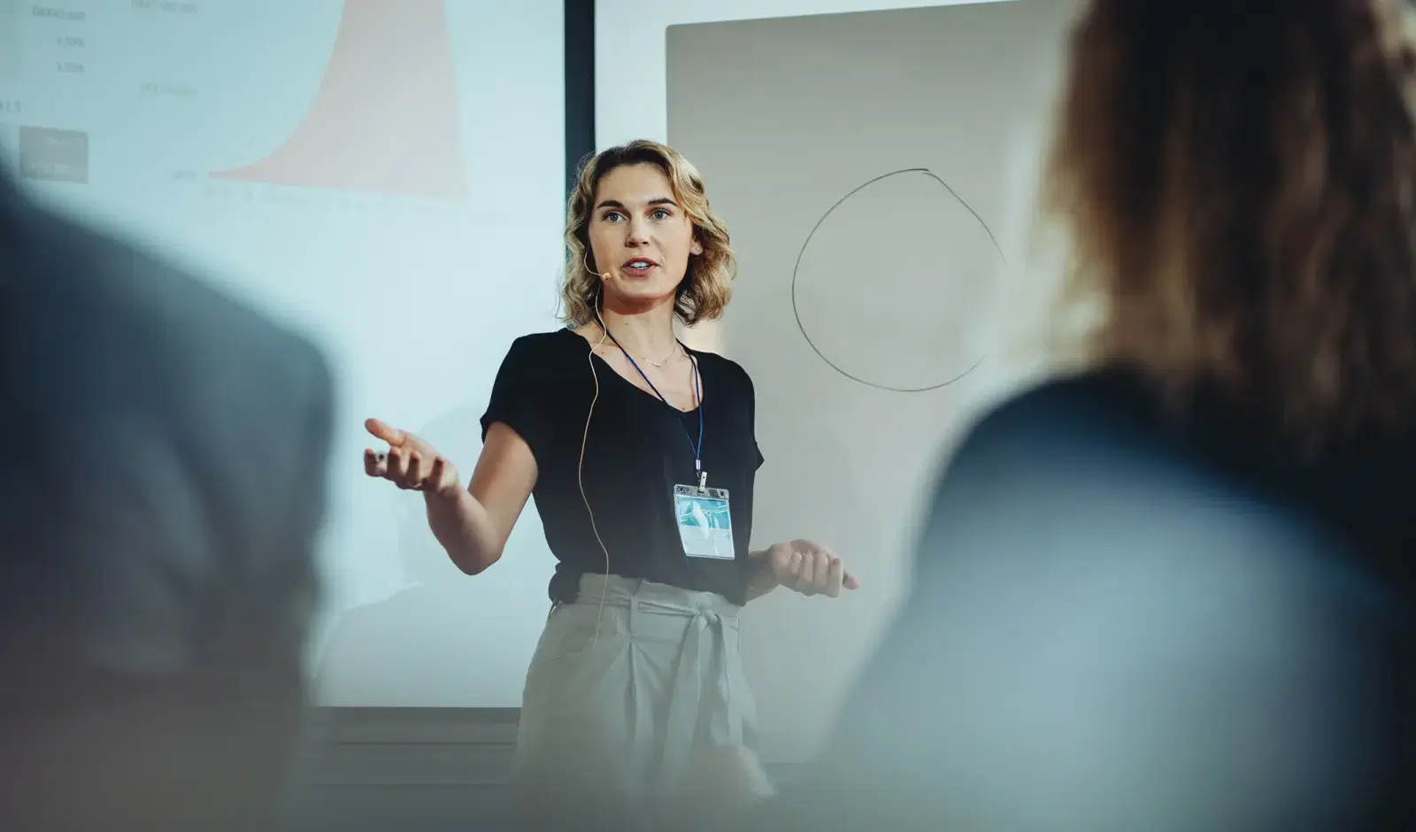 A woman presenting on stage to an audience